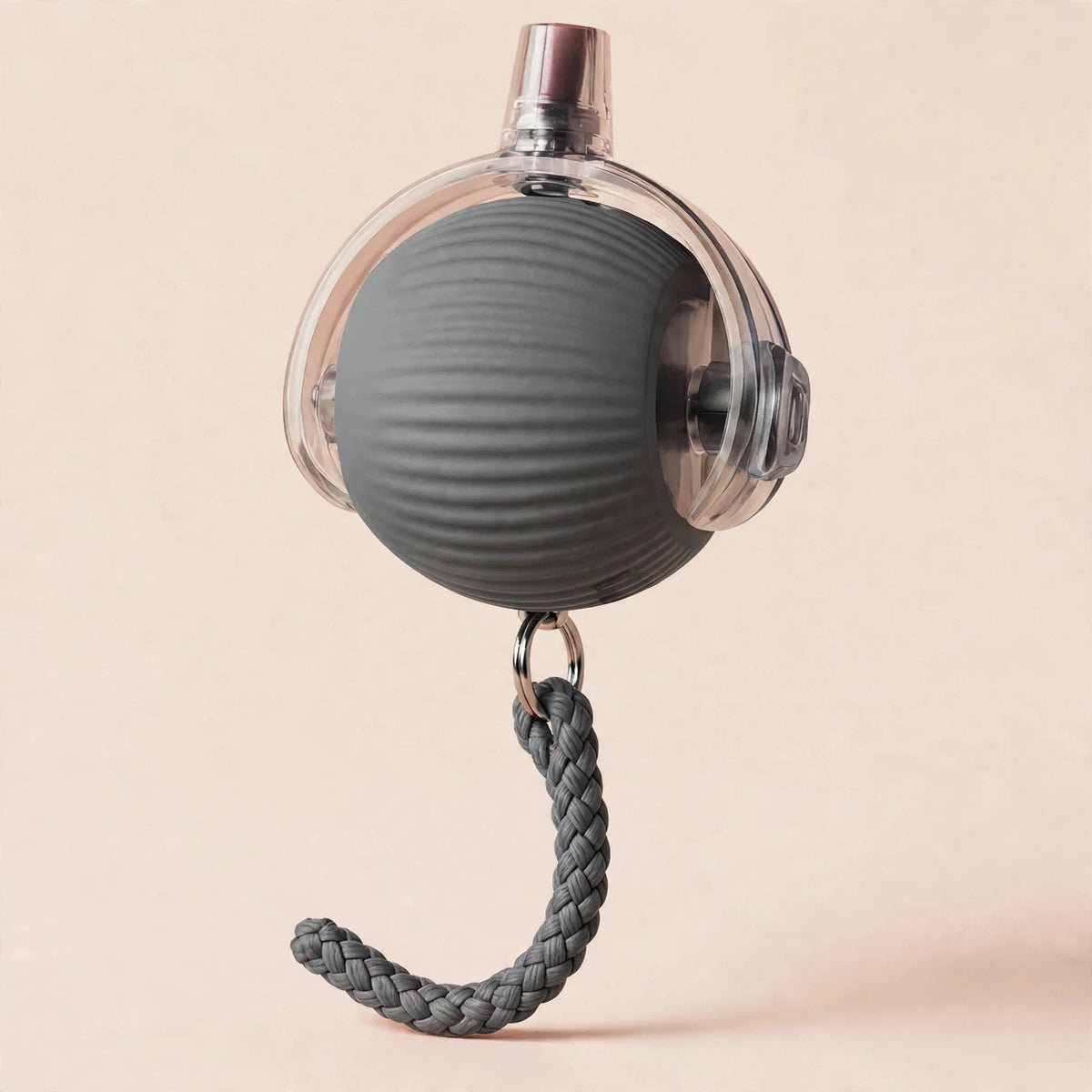 Gray rope-textured smart rolling cat ball with a transparent outer shell, metal USB charging port on top, and a braided gray rope tail hanging below, on a beige background.