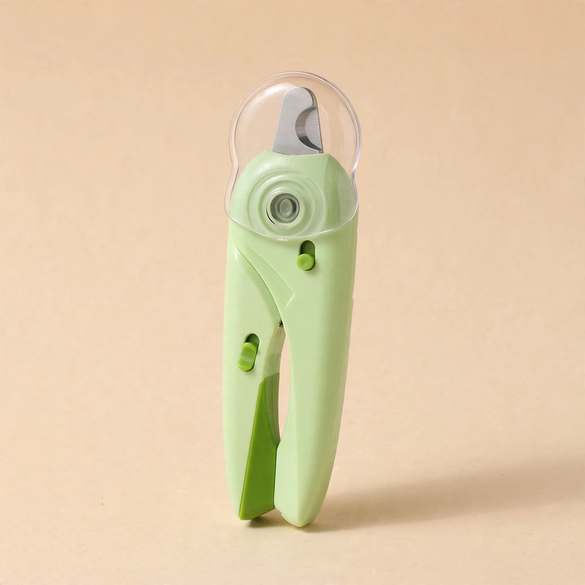 Light green LED pet nail clipper with dark green handle accents, a transparent anti-splash guard over the steel blade, standing upright on a beige background.
