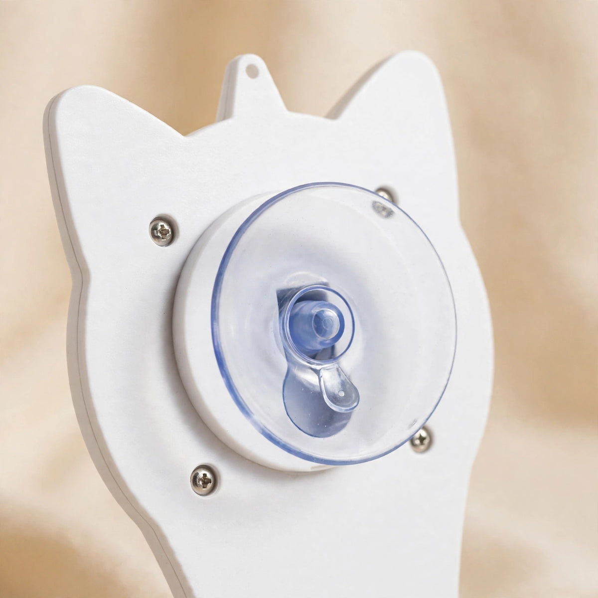 Close-up of the back of the white cat-face-shaped teaser showing its transparent suction cup mount secured with screws.