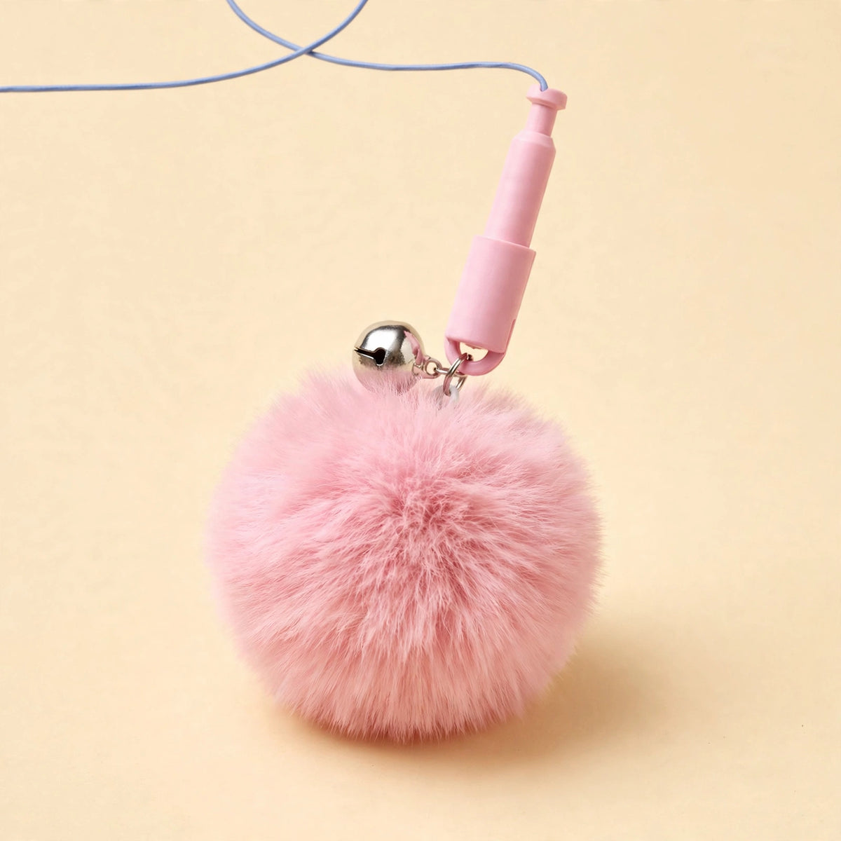 Close-up of the fluffy pink pom-pom ball head with a silver bell attached to the pink quick-release connector and blue cord.