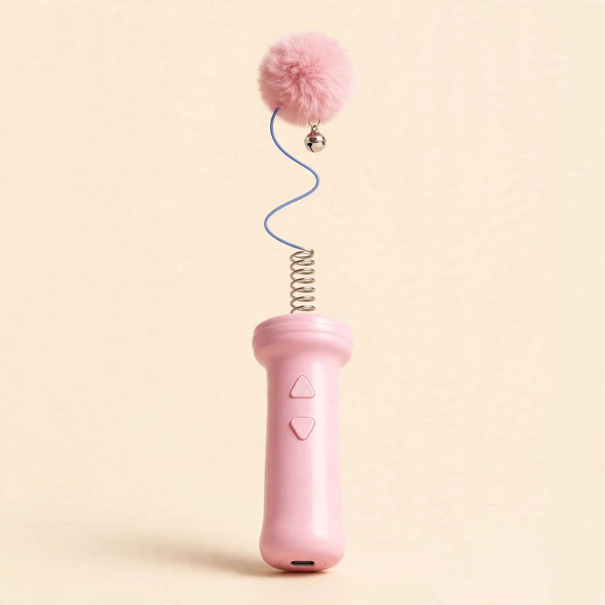 Cherry-pink electric retractable cat teaser wand with a pink handle, metal spring coil, blue cord, and fluffy pink pom-pom with a silver bell, on a beige background.